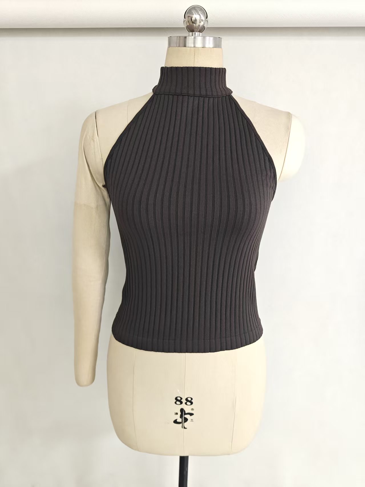 Women's high-neck sleeveless tank top in black displayed on a torso mannequin.