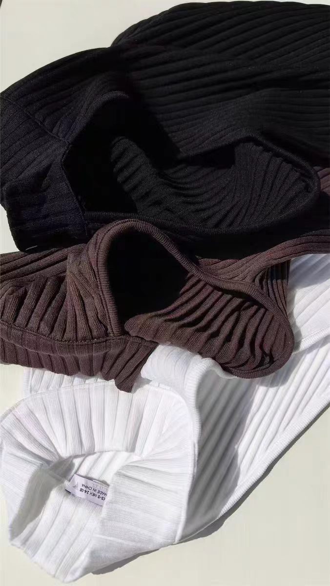 Black and brown women's high-neck tank tops stacked and folded together.