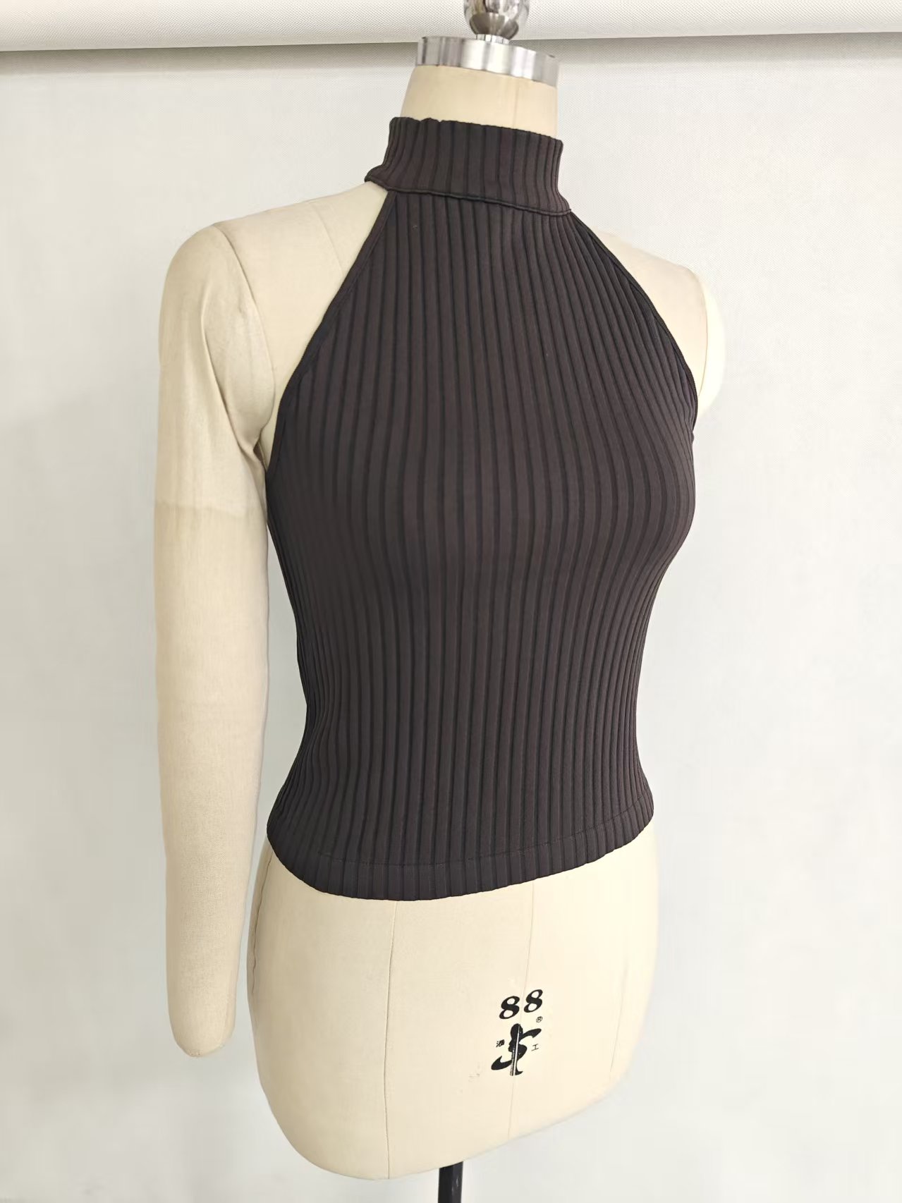 Close-up of black women's high-neck tank top on a mannequin showcasing fit and side seam detail.