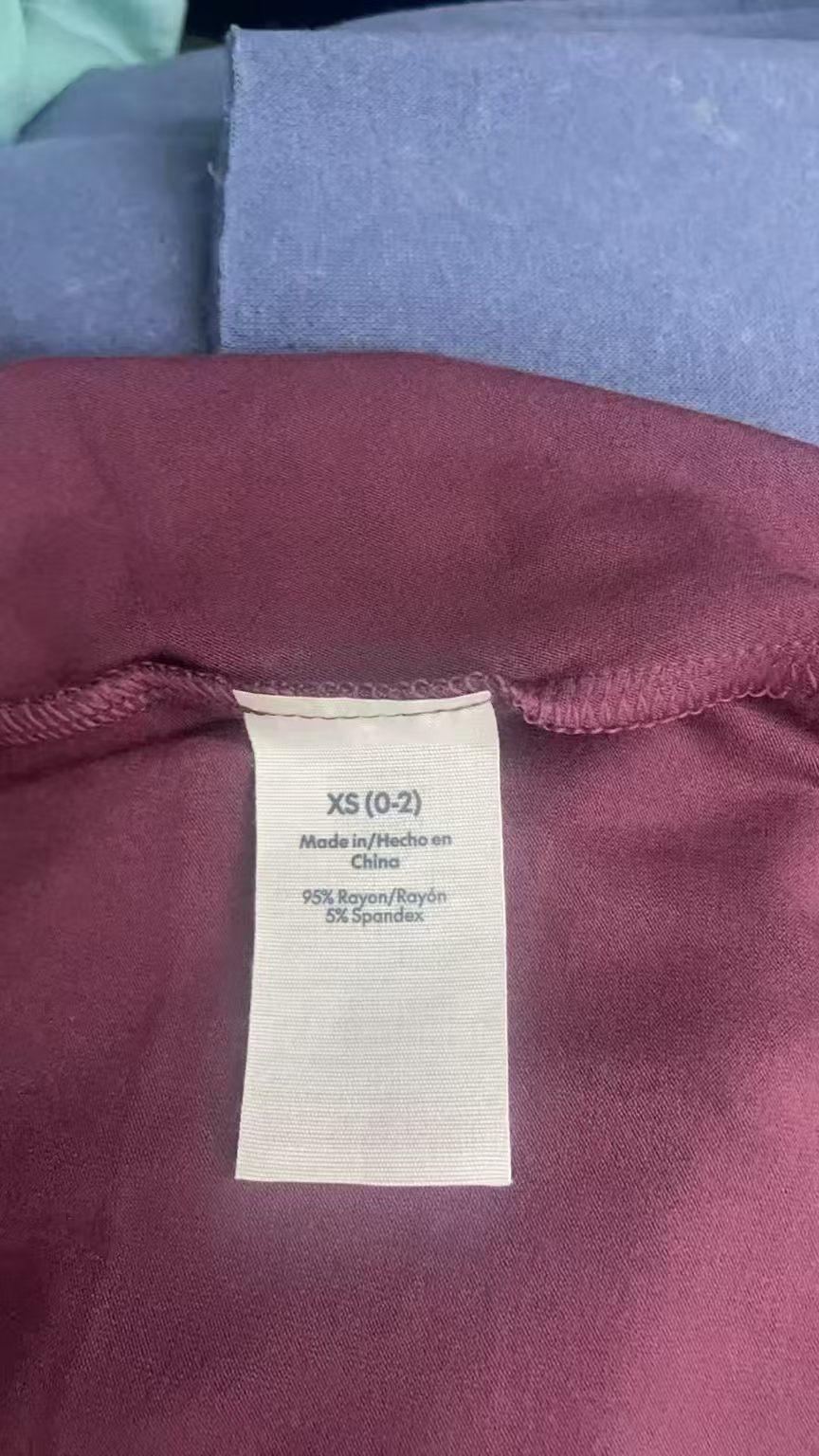 Folded plum wine women's long skirt with product tag laid flat.