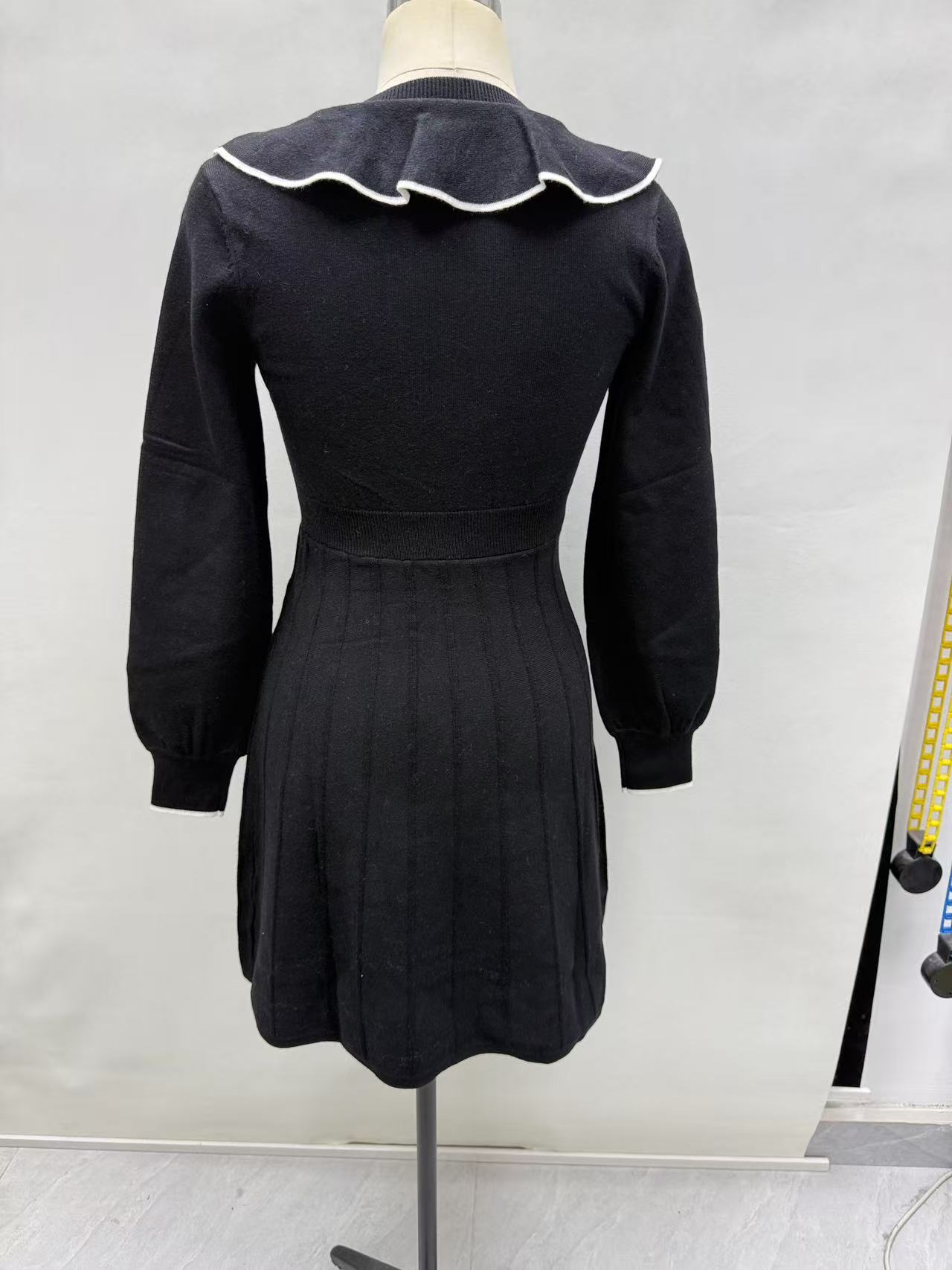 Back view of black women's long-sleeve dress displayed on a torso mannequin.