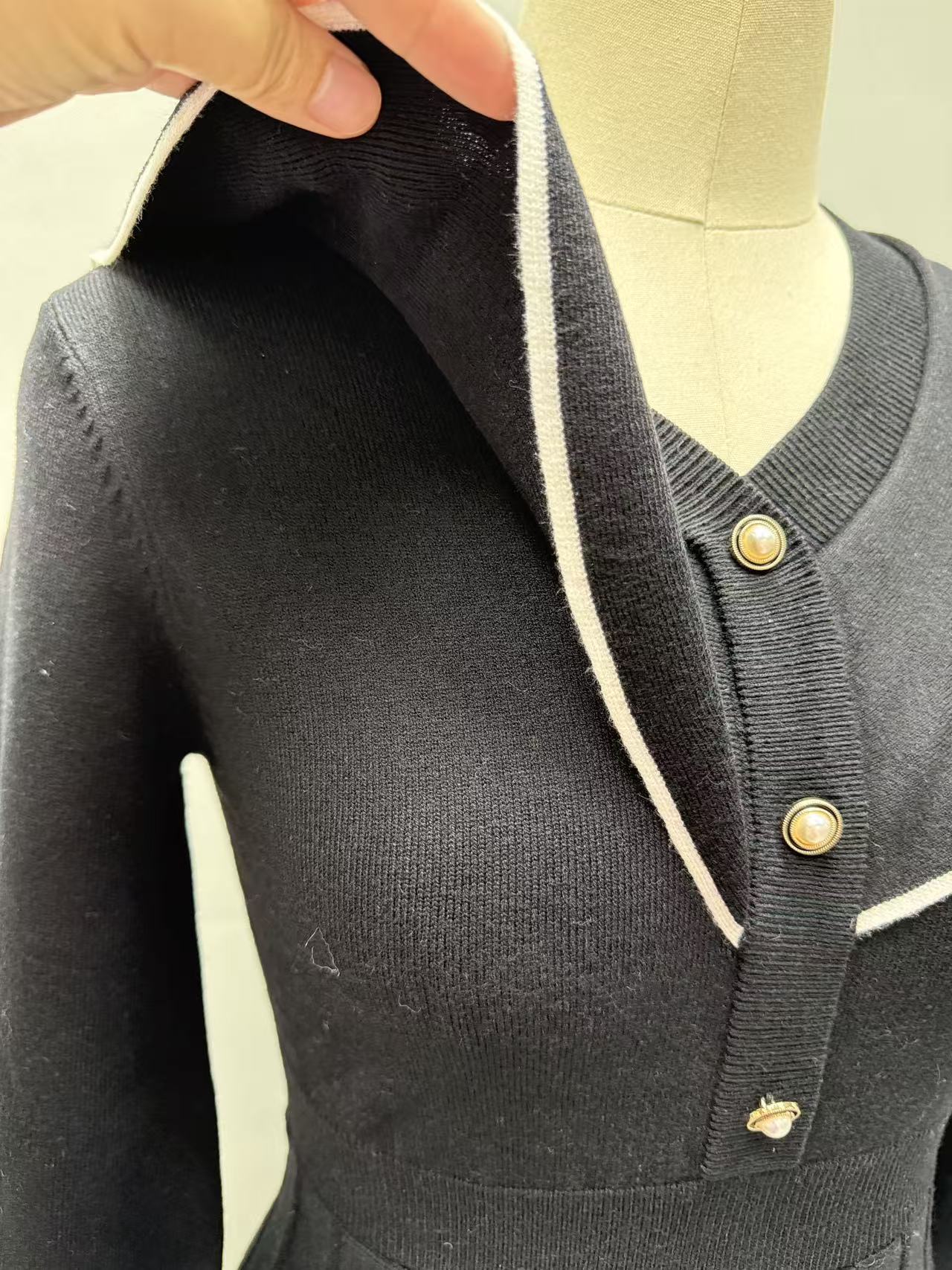 Close-up shot highlighting the white sailor collar and neckline of the black women's dress.