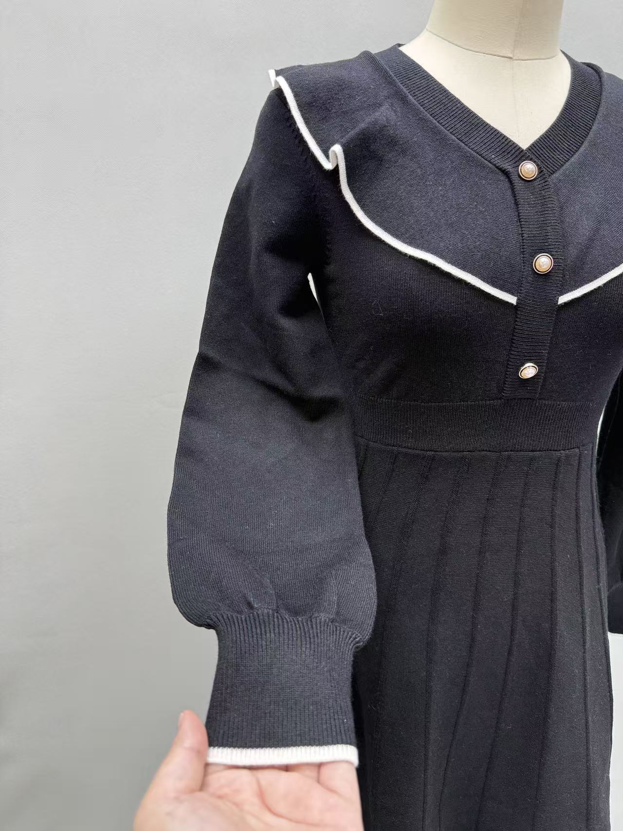 Front view of black women's long-sleeve dress with white collar detail on a torso mannequin.