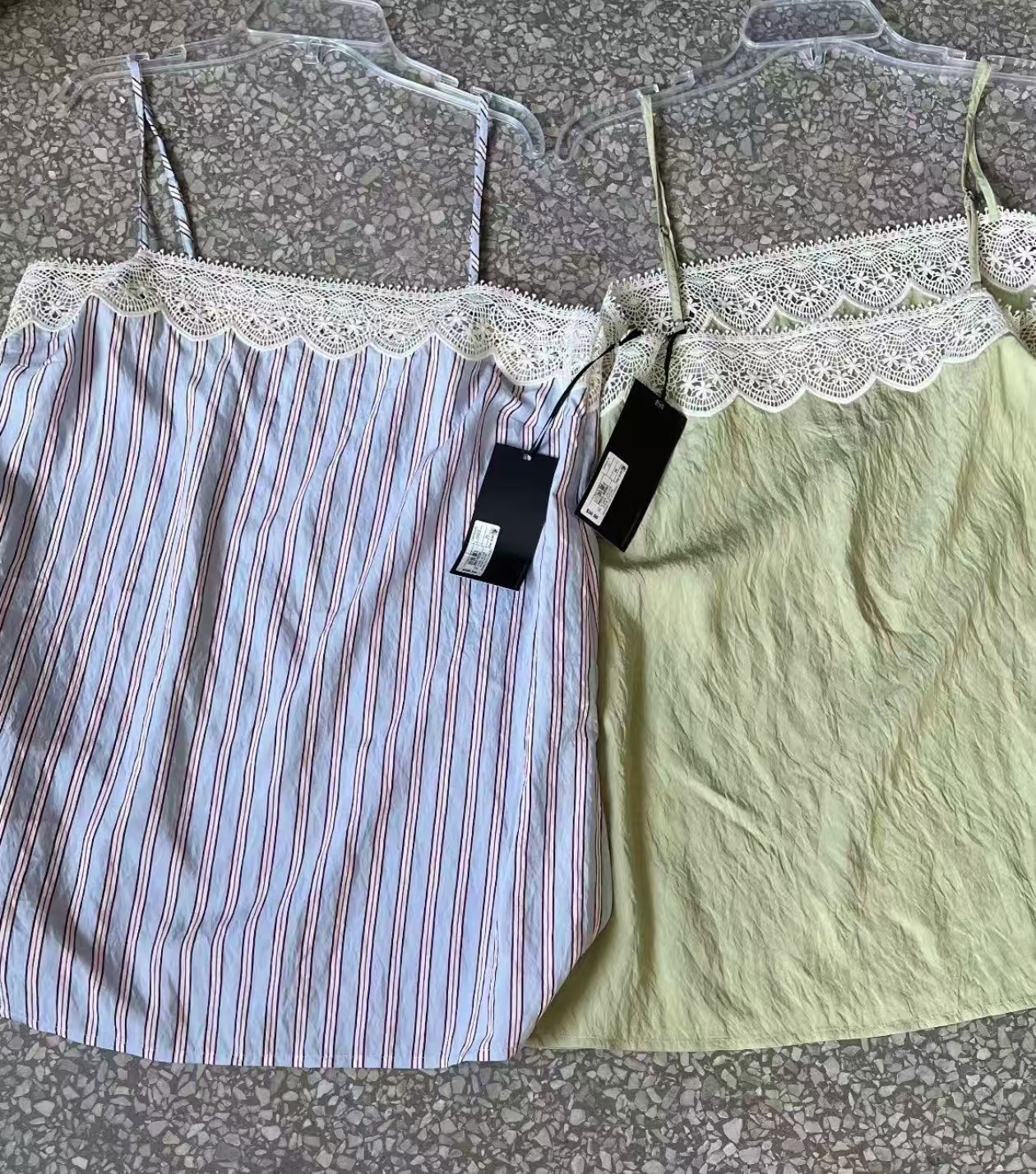 Sage green and blue/red striped women's wrap dresses stacked and laid flat on a light-colored surface.