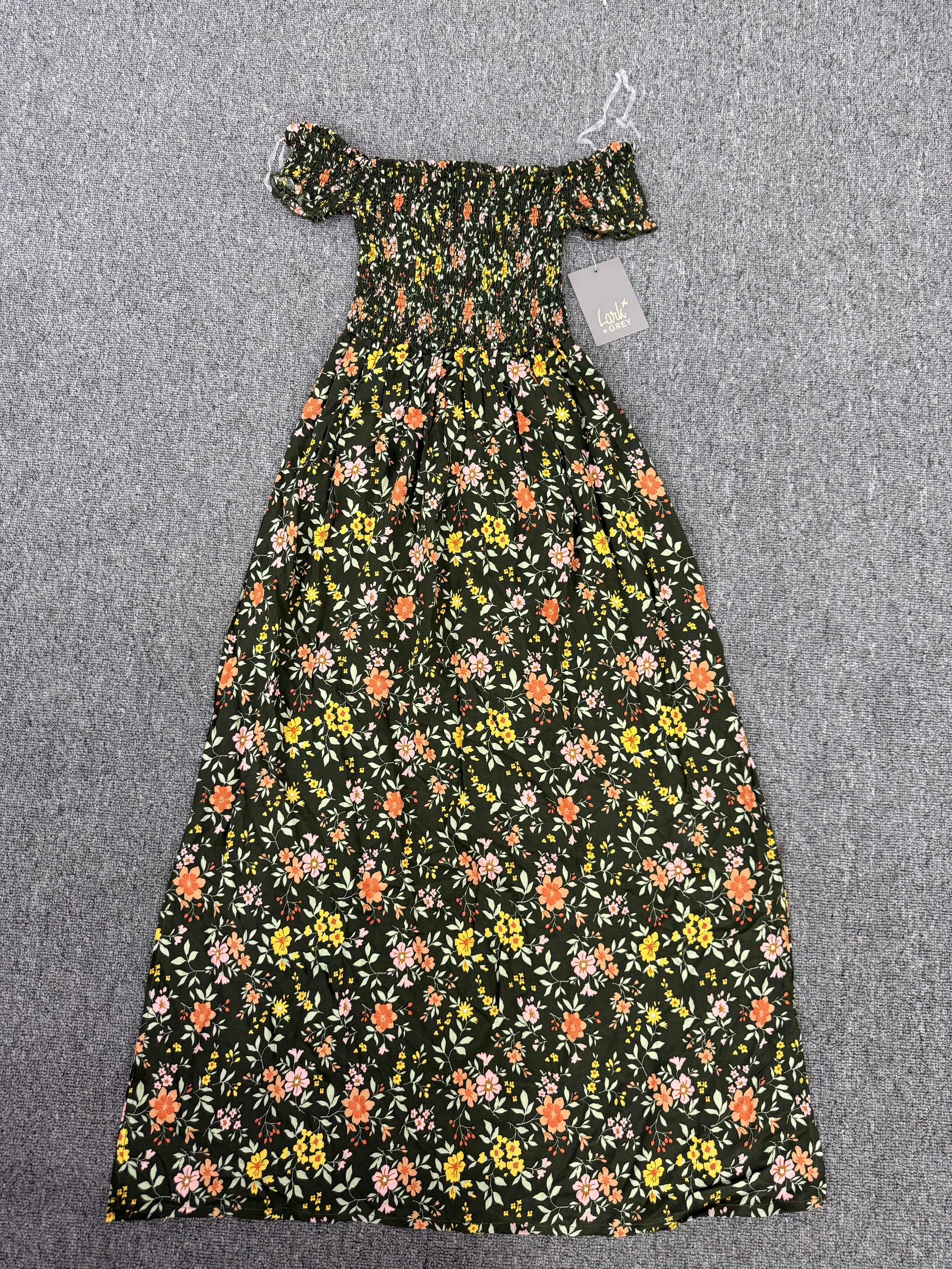 Women's green and yellow floral printed midi dress laid flat on a neutral background.