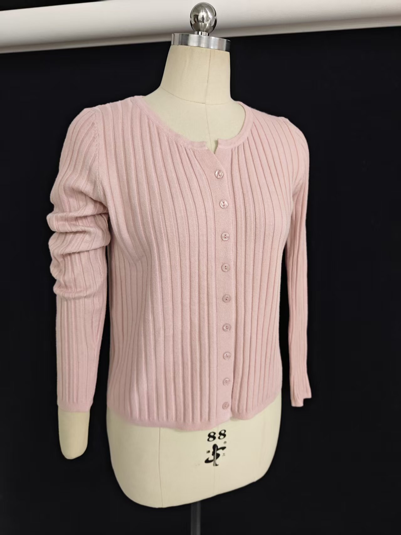 Close-up shot of the black women's V-neck cardigan highlighting the ribbed cuffs, buttons, and fabric texture.