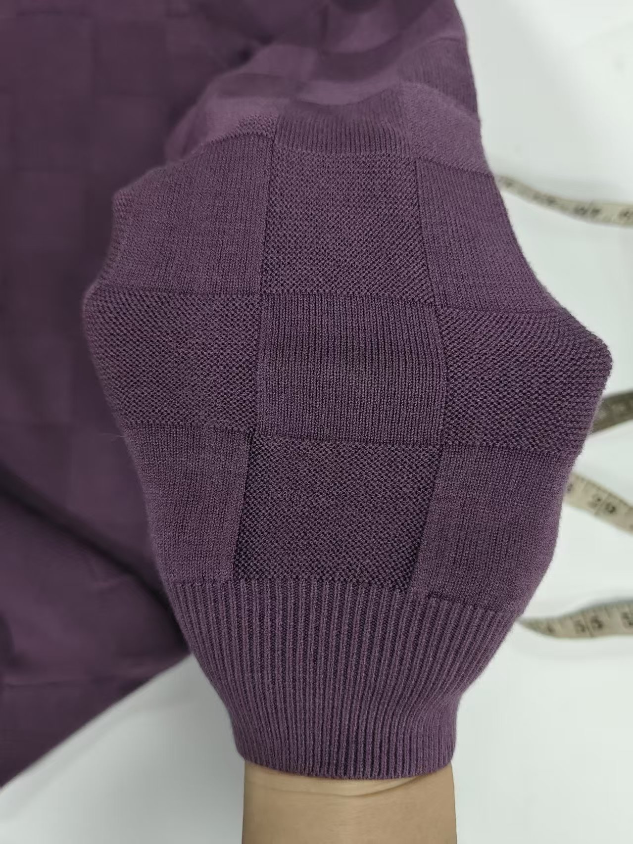 Close up detail of cable knit sleeve cuff on men's purple sweater TF8809