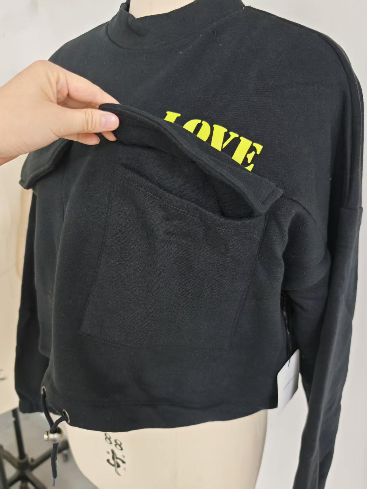 Close up front pocket and graphic print detail ladies black cropped sweatshirt TF8851