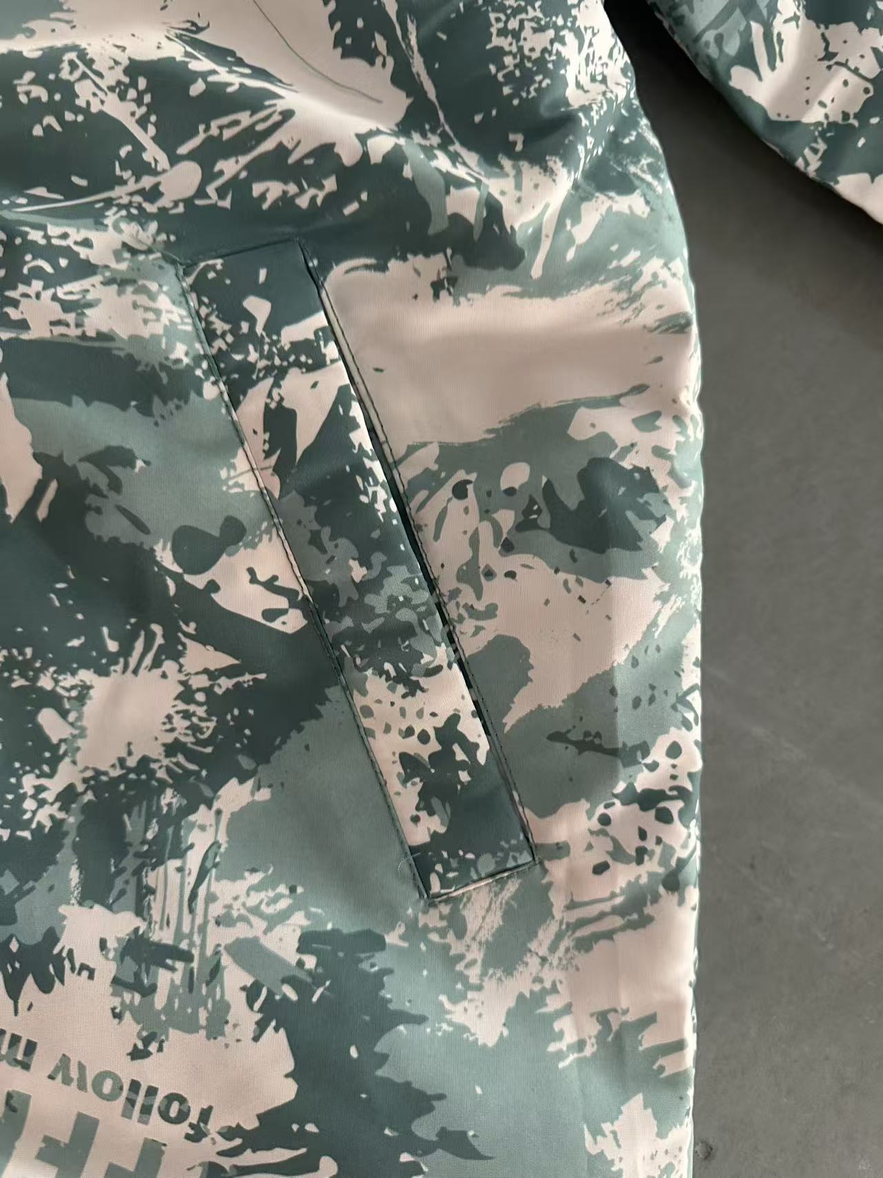 Close up of green tree camouflage print pattern on boy's jacket TF8999