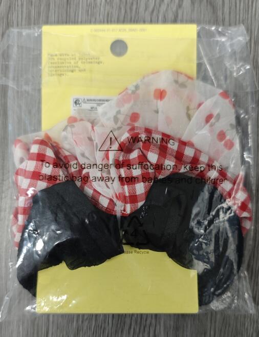 Close up of girl's gingham and cherry elastic hair ties TF6682