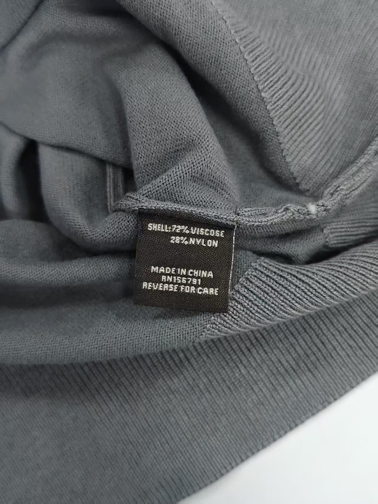 Inner seam and hem detail of men's quarter-zip sweater TF7822