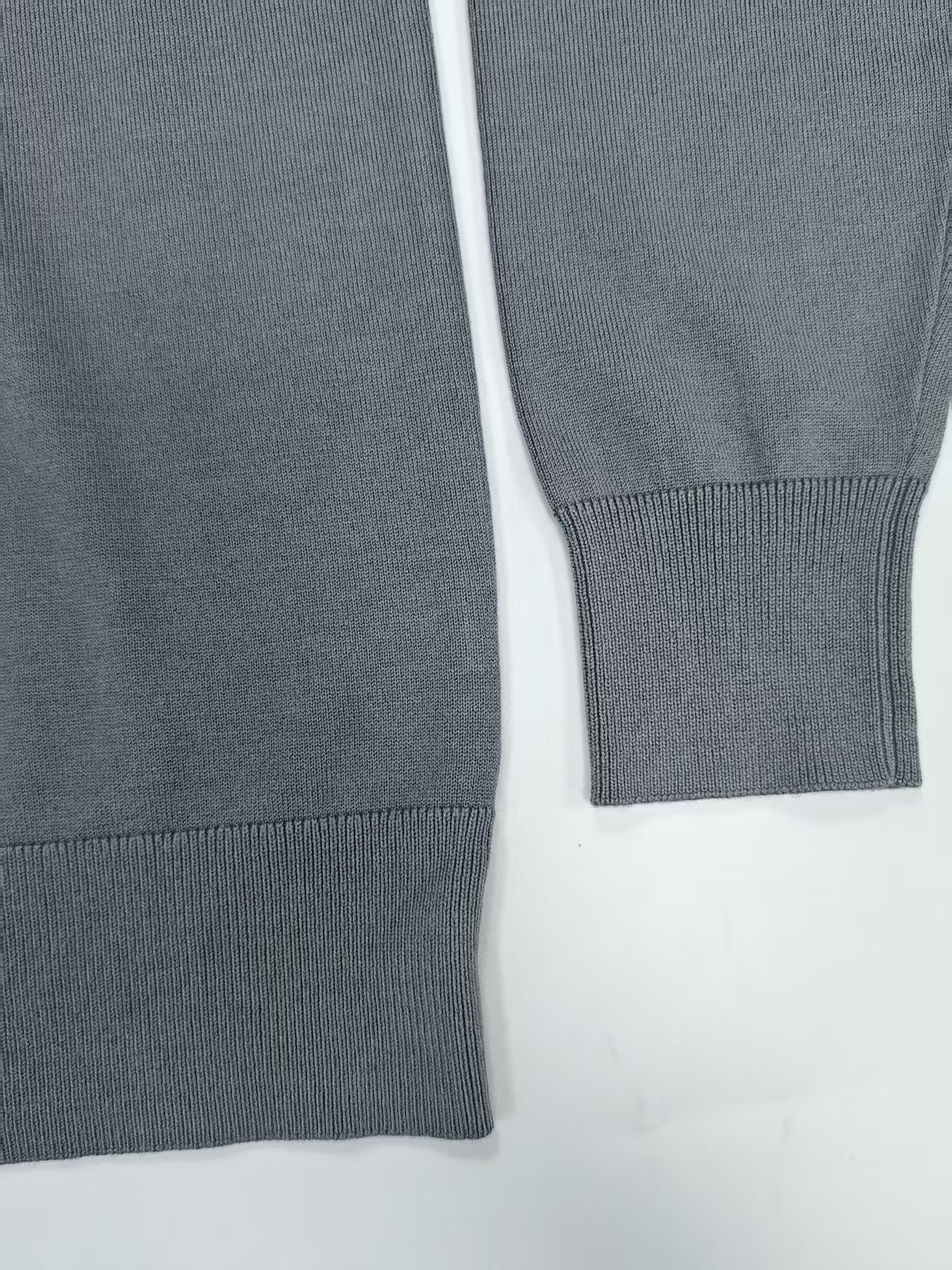 Side view and cuff detail of men's quarter-zip sweater TF7822