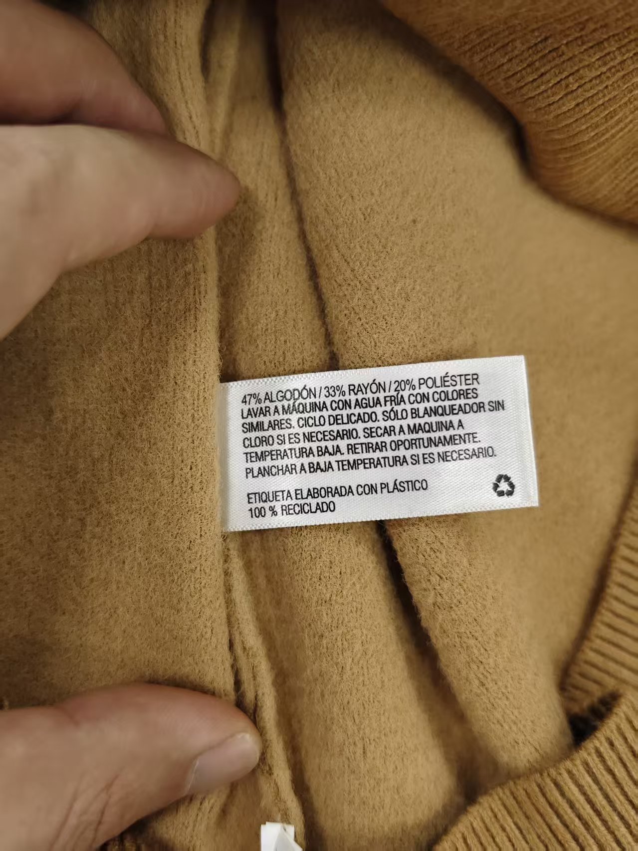 Collar label and neck seam detail on men's sweater TF7953