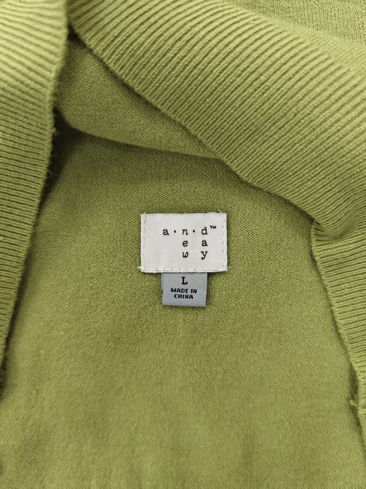 Collar label and neck seam detail on ladies' green sweater TF8182