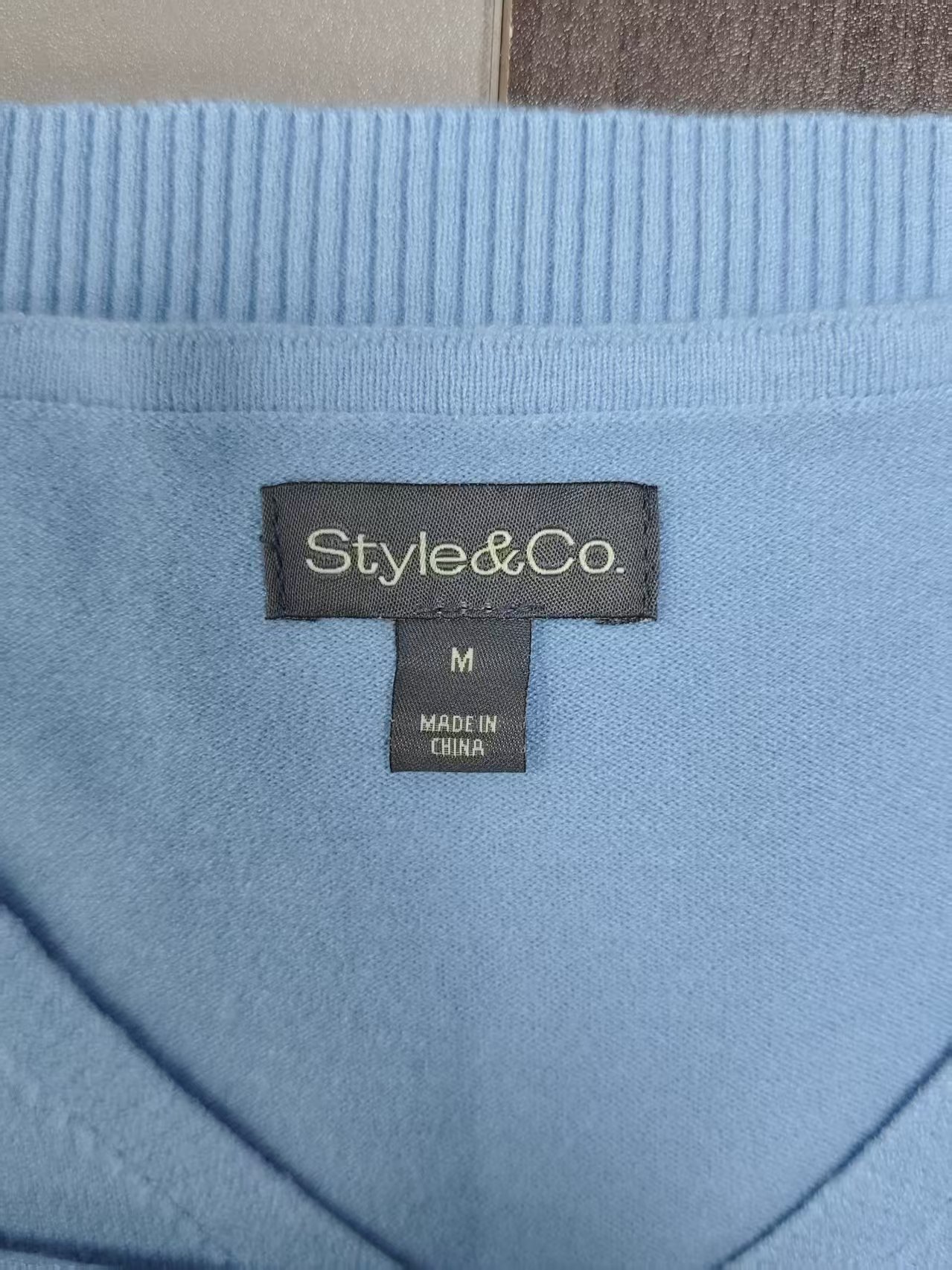 Collar label and neck seam detail on ladies' sweater TF8550