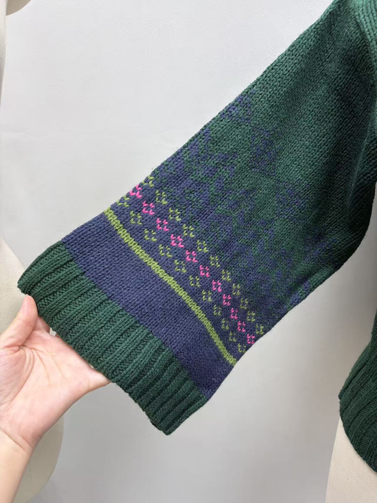 Close-up detail of ribbed cuff and knit fabric on green cardigan