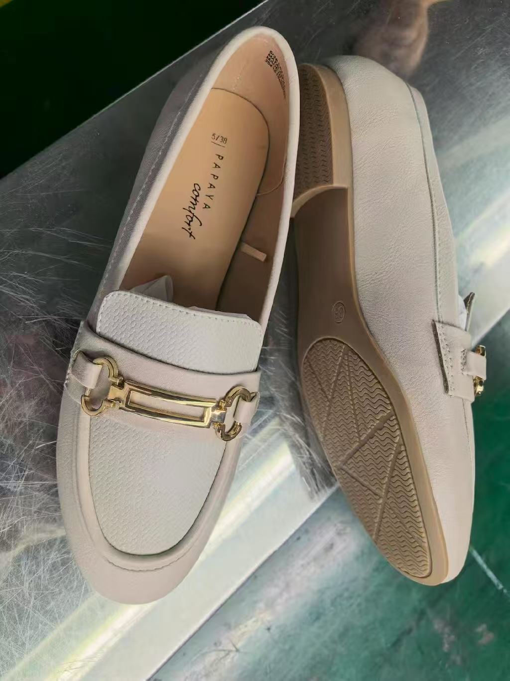 Pair of women's off-white flat loafers with gold buckle