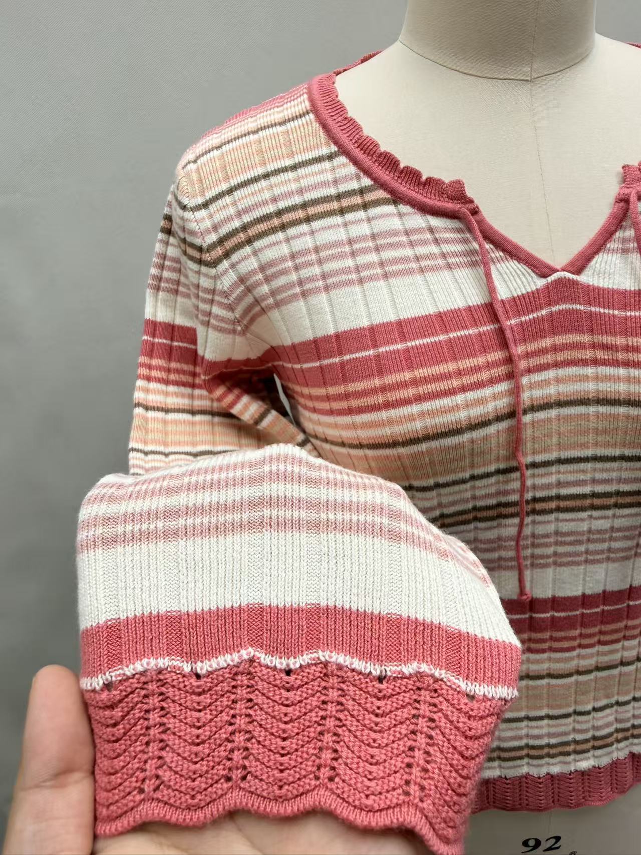 Close-up detail of red striped cotton knit fabric and crew neck