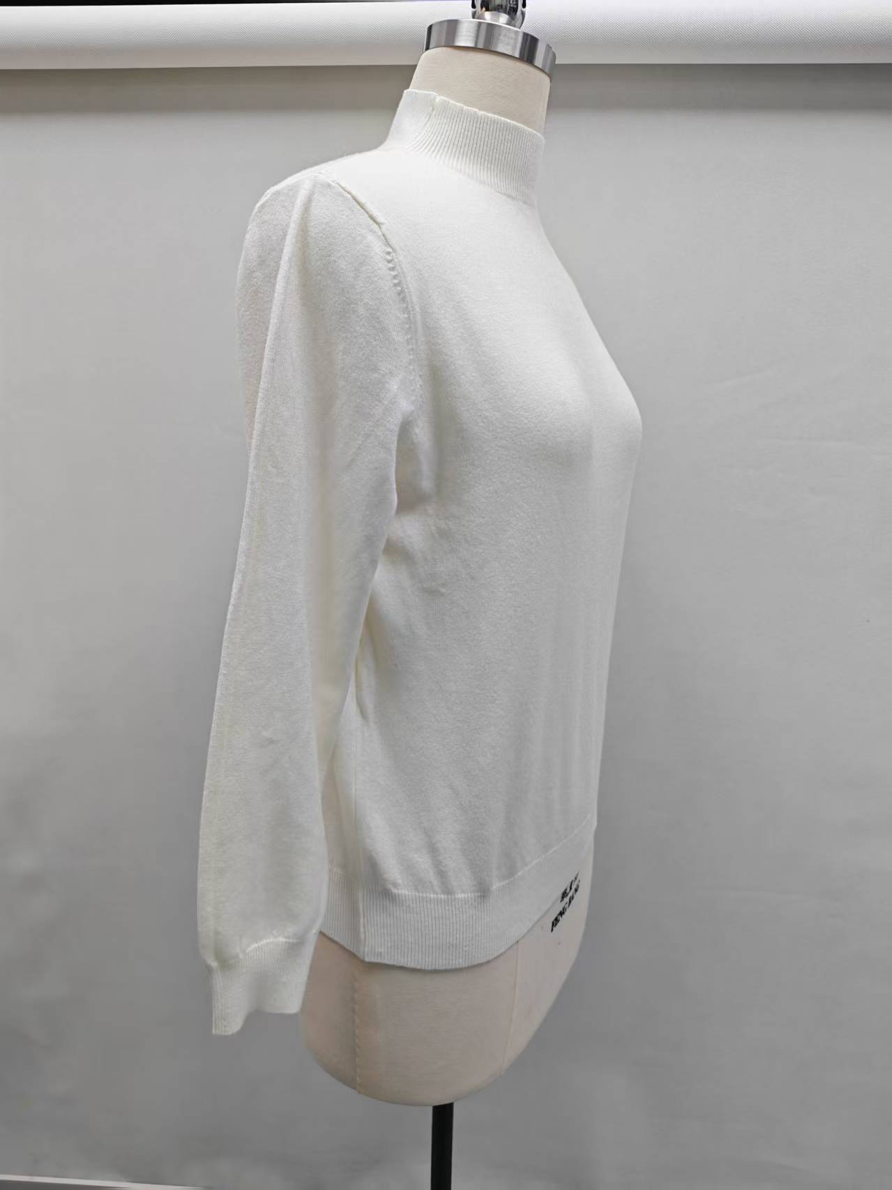 Front view of women's off-white ribbed knit pullover sweater