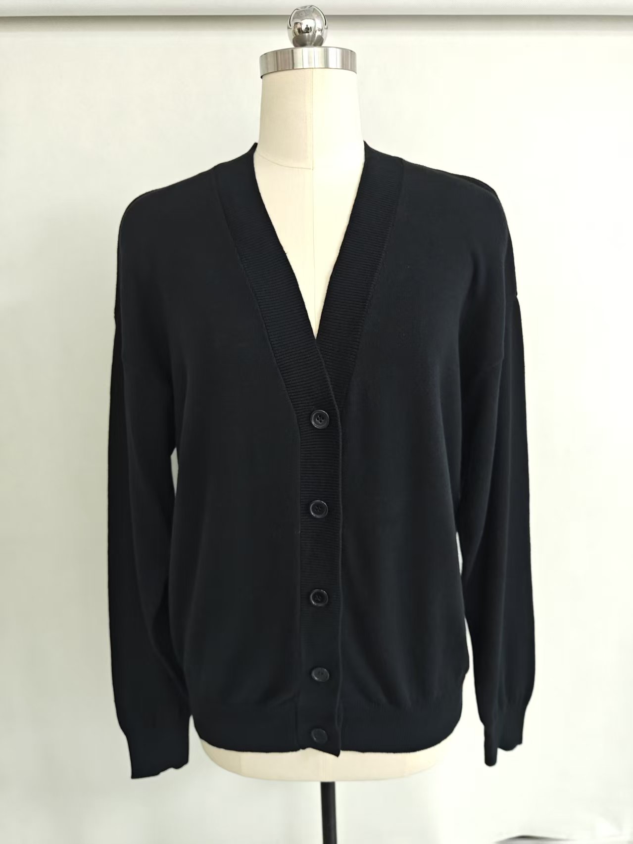 Flat lay view of classic black women's cotton cardigan sweater