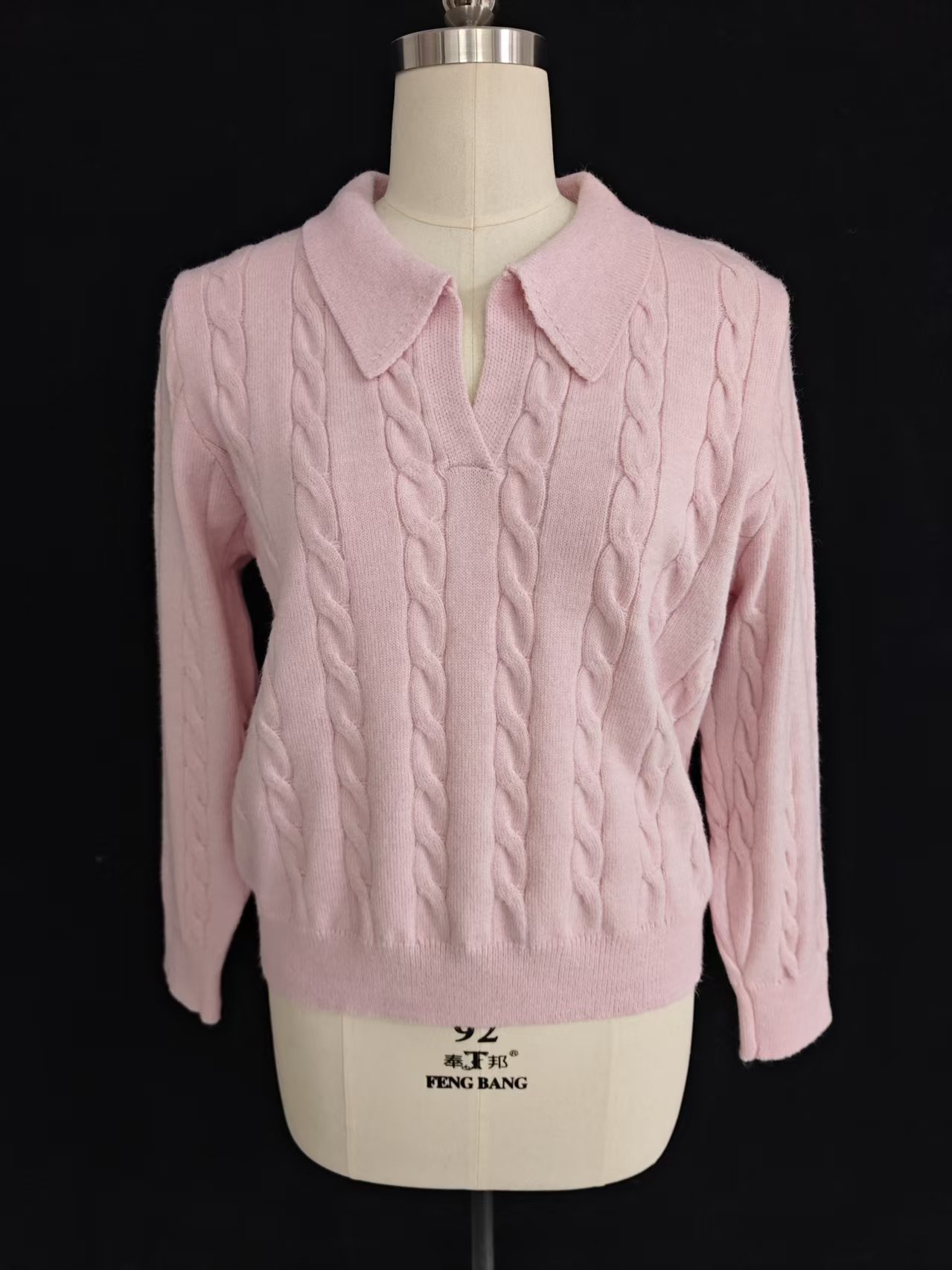 Front view of women's pink polo collar cable knit sweater