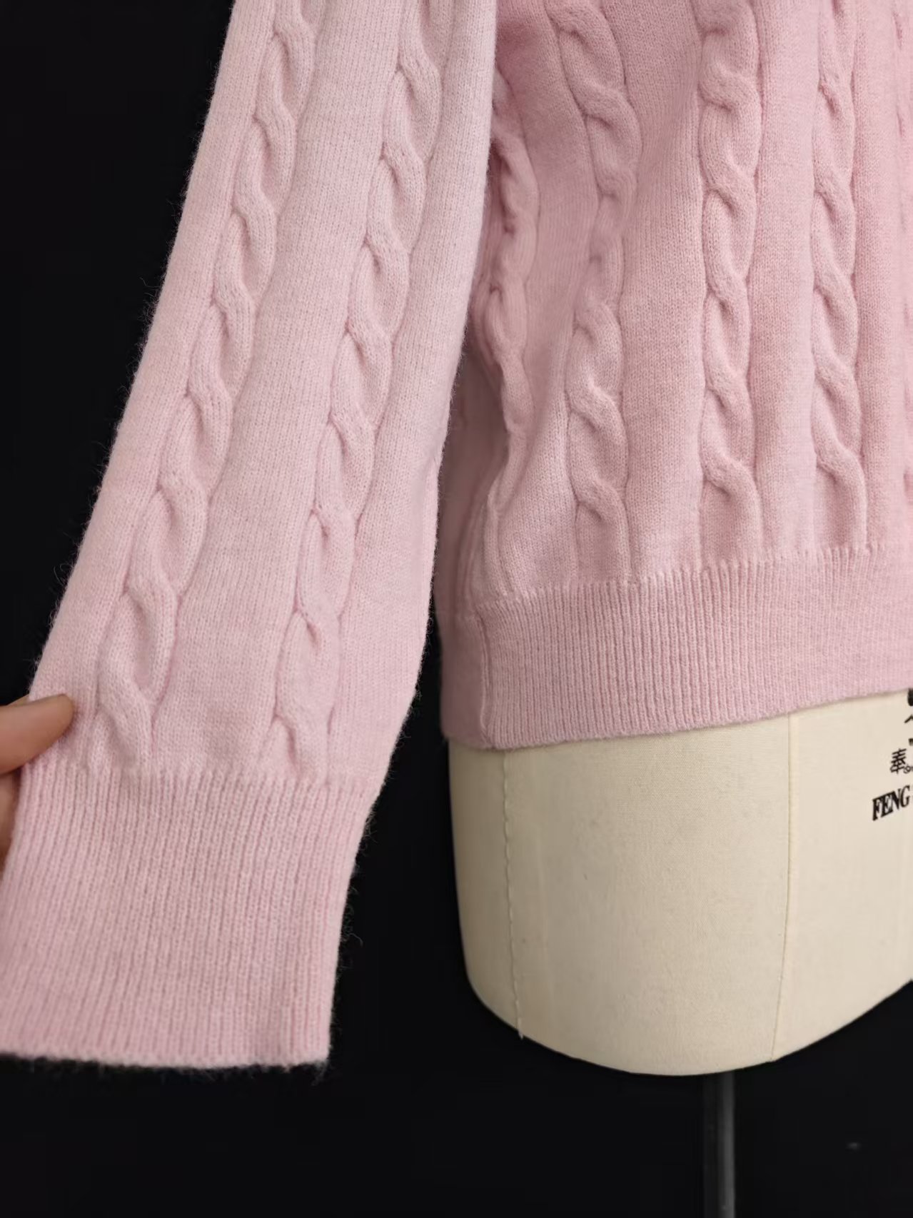 Close-up of polo collar and cable knit sleeve on pink sweater