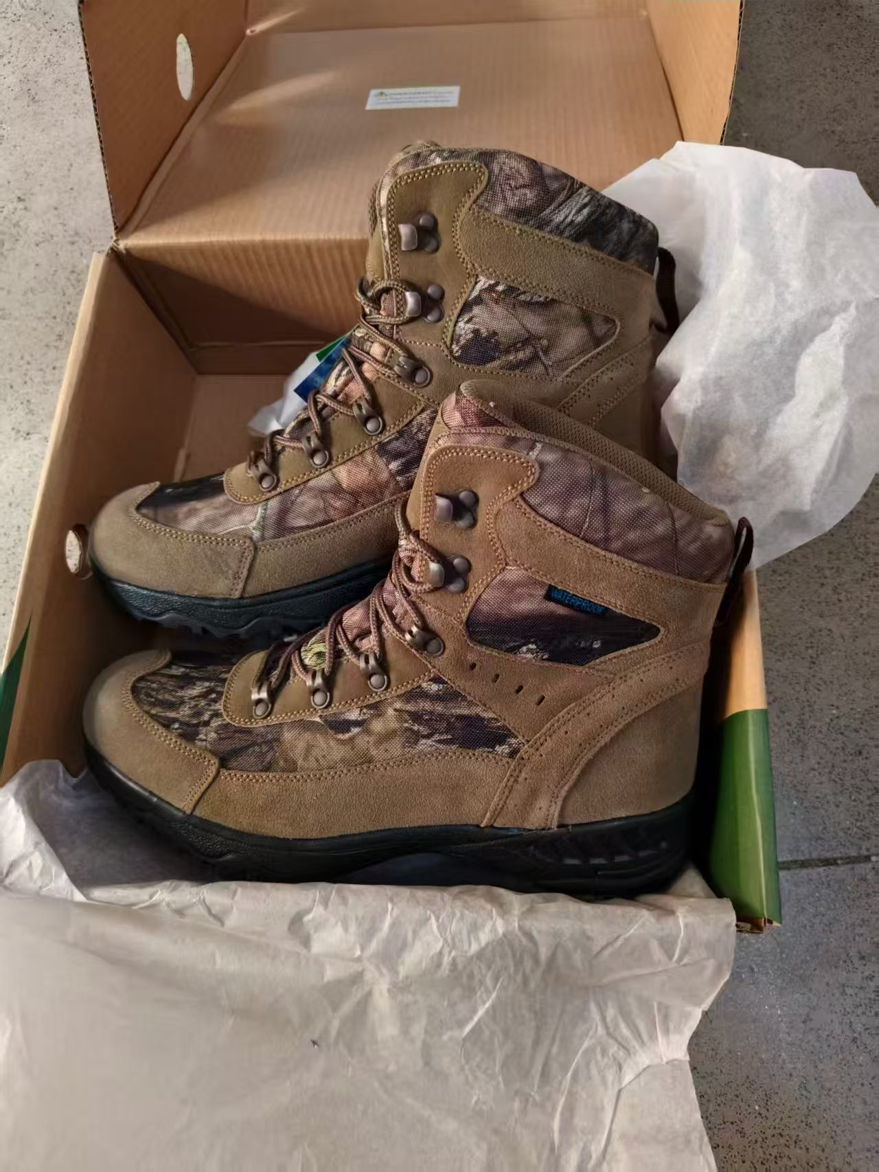 Pair of men's brown and camouflage tactical outdoor boots