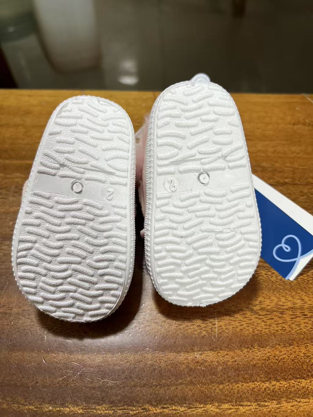 Side view of infant pink plush crib shoes wholesale