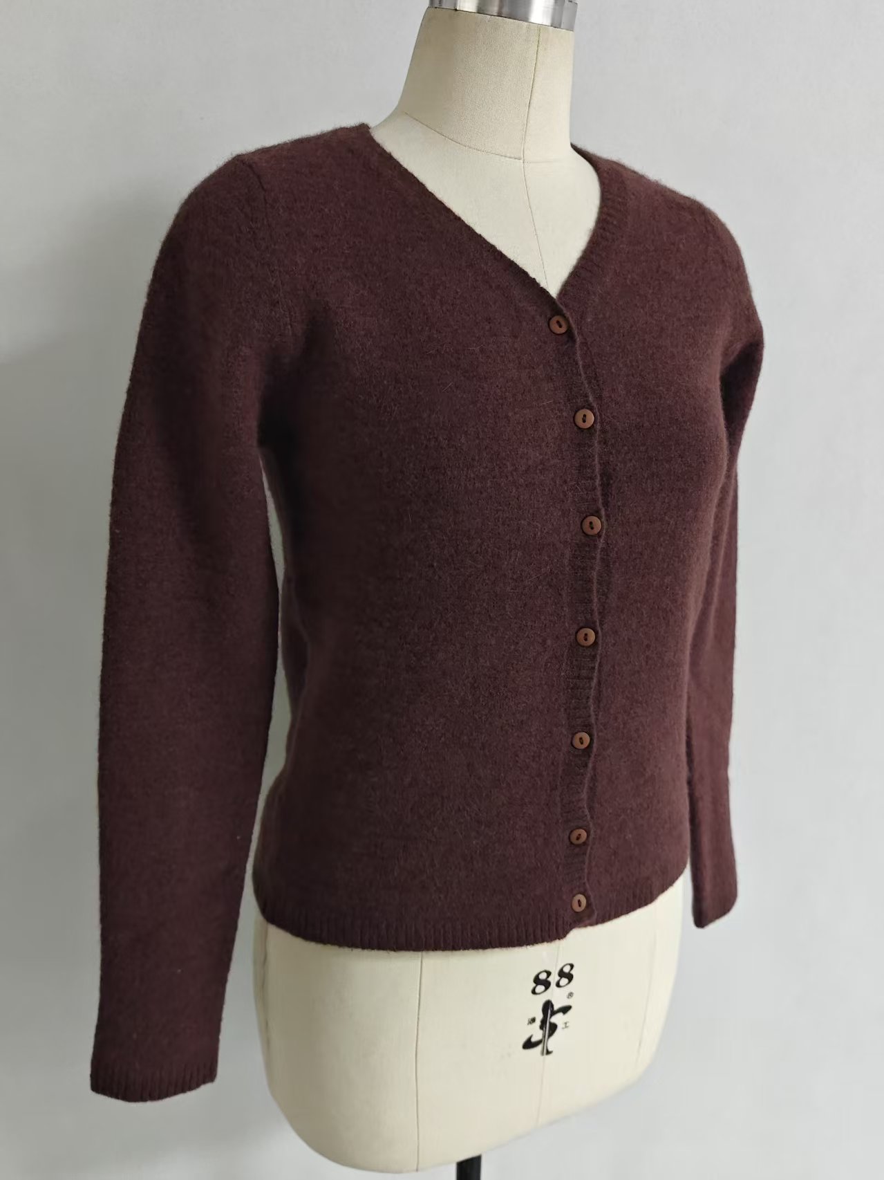 Side view of women's long sleeve button-up knit cardigan