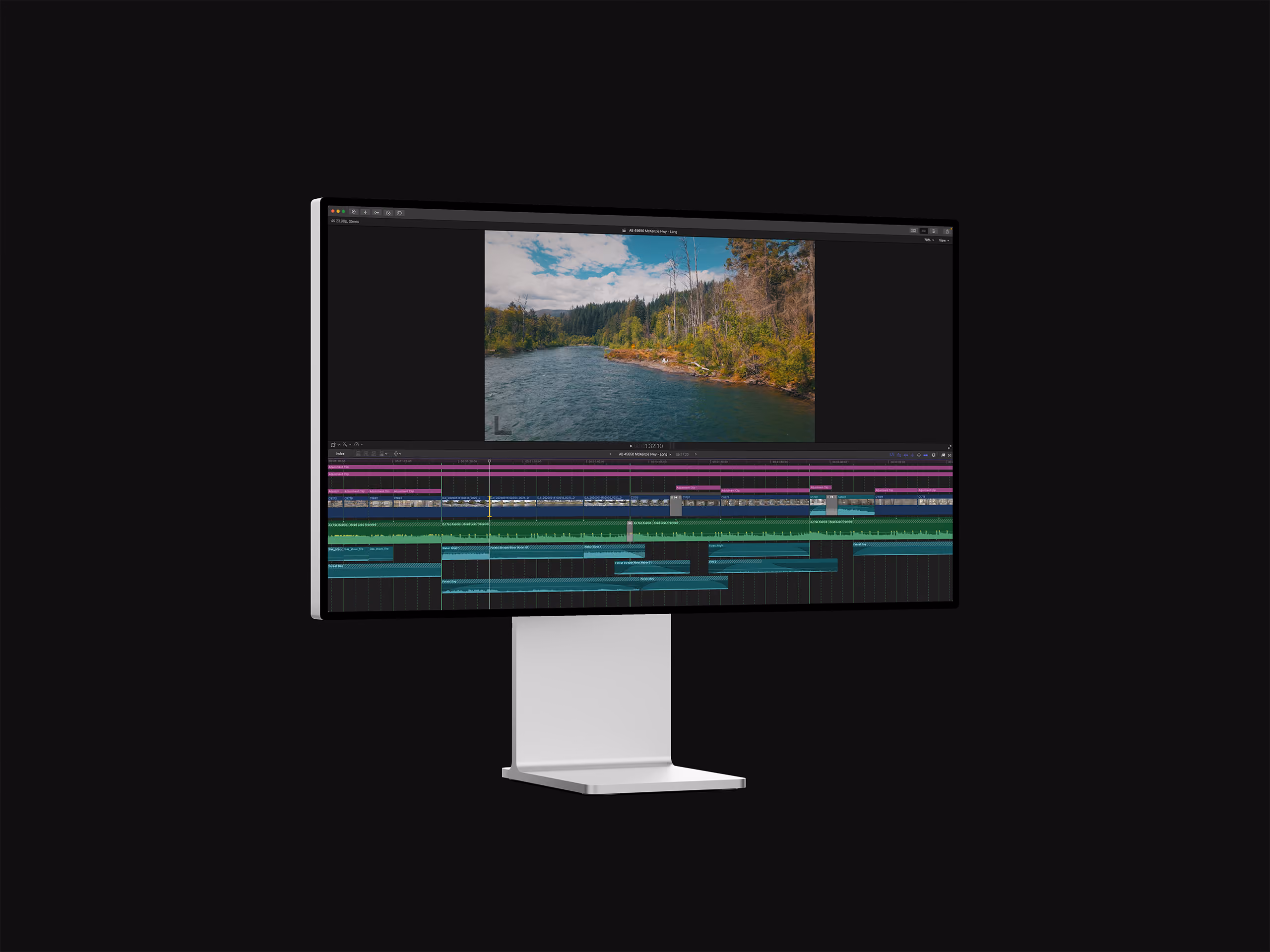 Modern monitor displaying video editing software with landscape footage of river and trees.