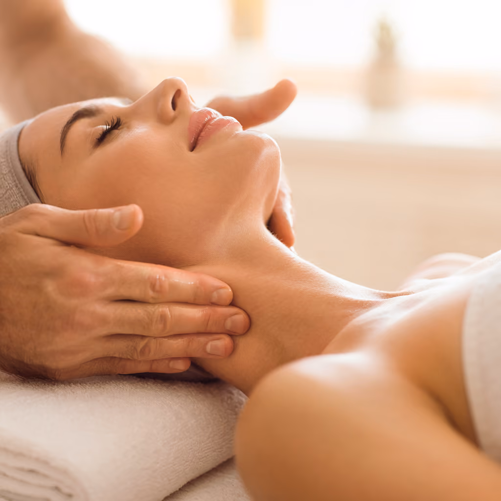 Entspannte Frau erhält eine lymphatische Drainage-Massage an Hals und Dekolleté