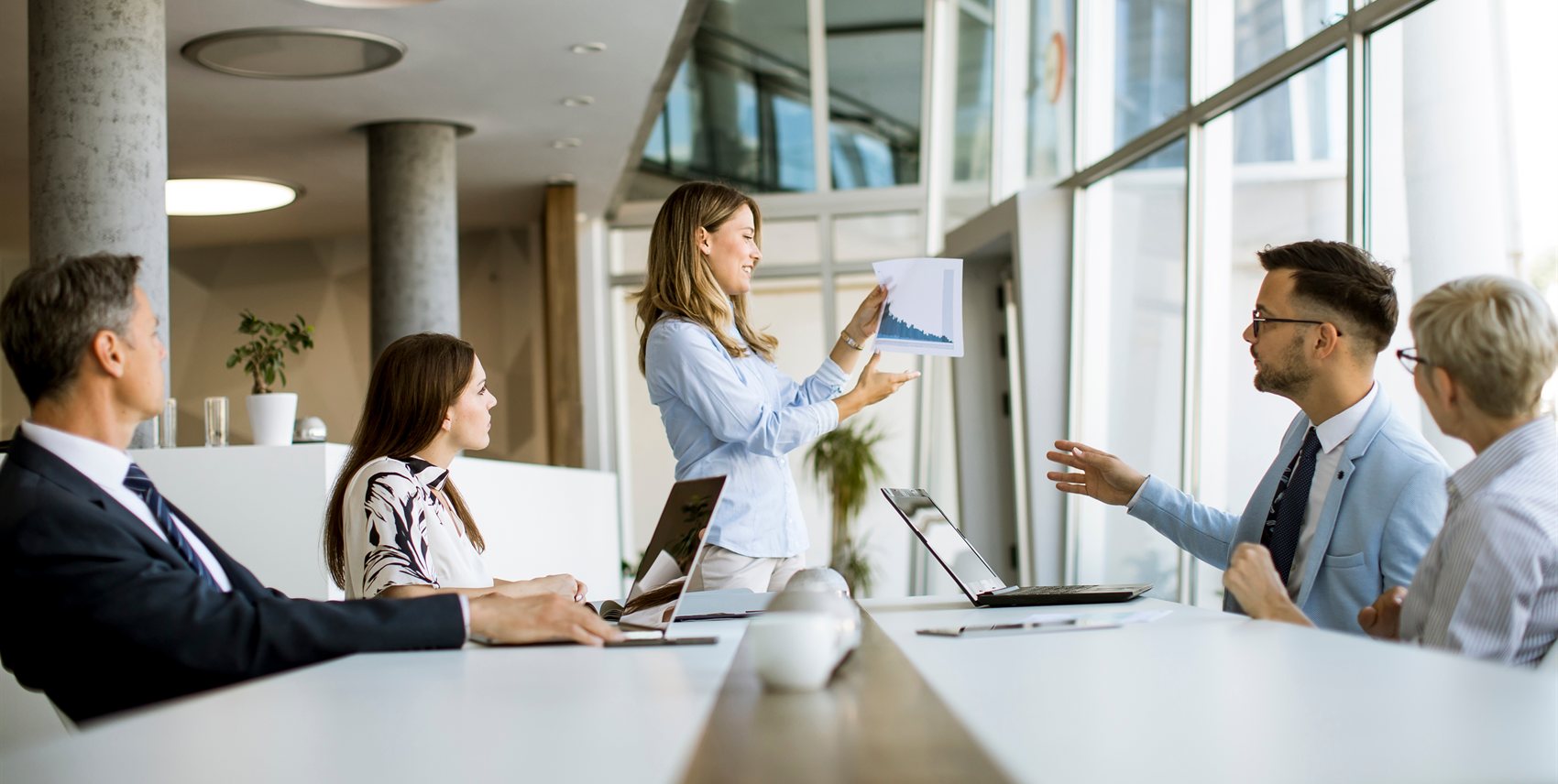 Colleagues reviewing a presentation together in a bright meeting room
