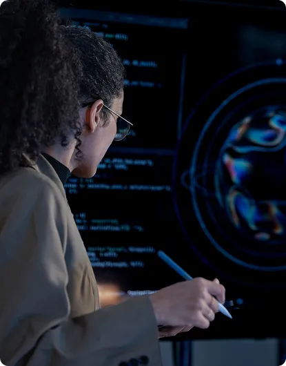 An engineer annotating code on a large screen in a darkened room