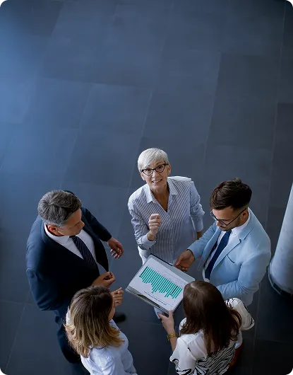 A team viewed from above, gathered around a printed performance report
