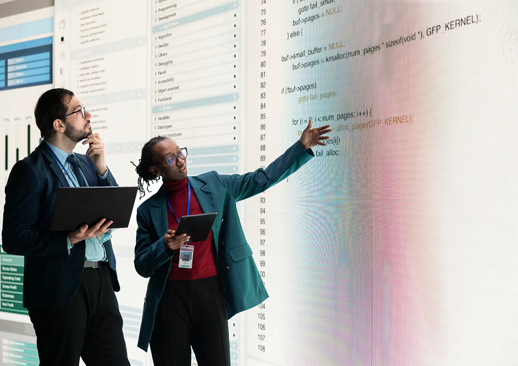 Two business professionals reviewing technology and software architecture on a digital display