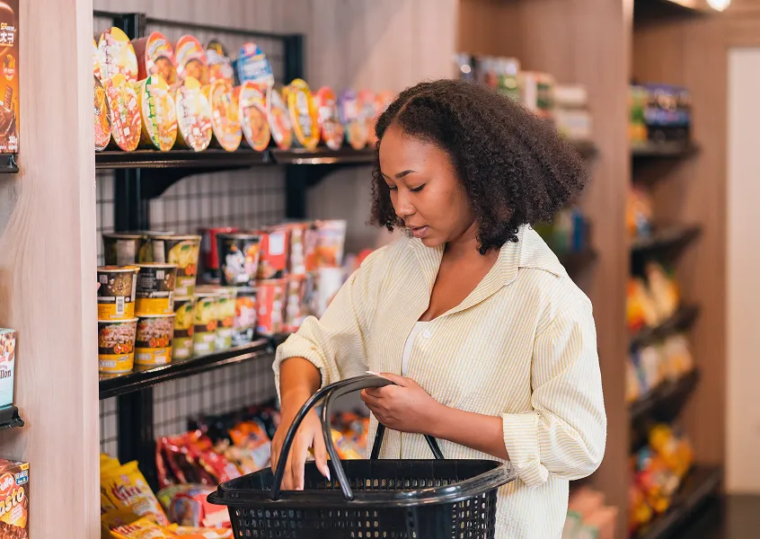 Retail shopper selecting packaged consumer products from a grocery store shelf