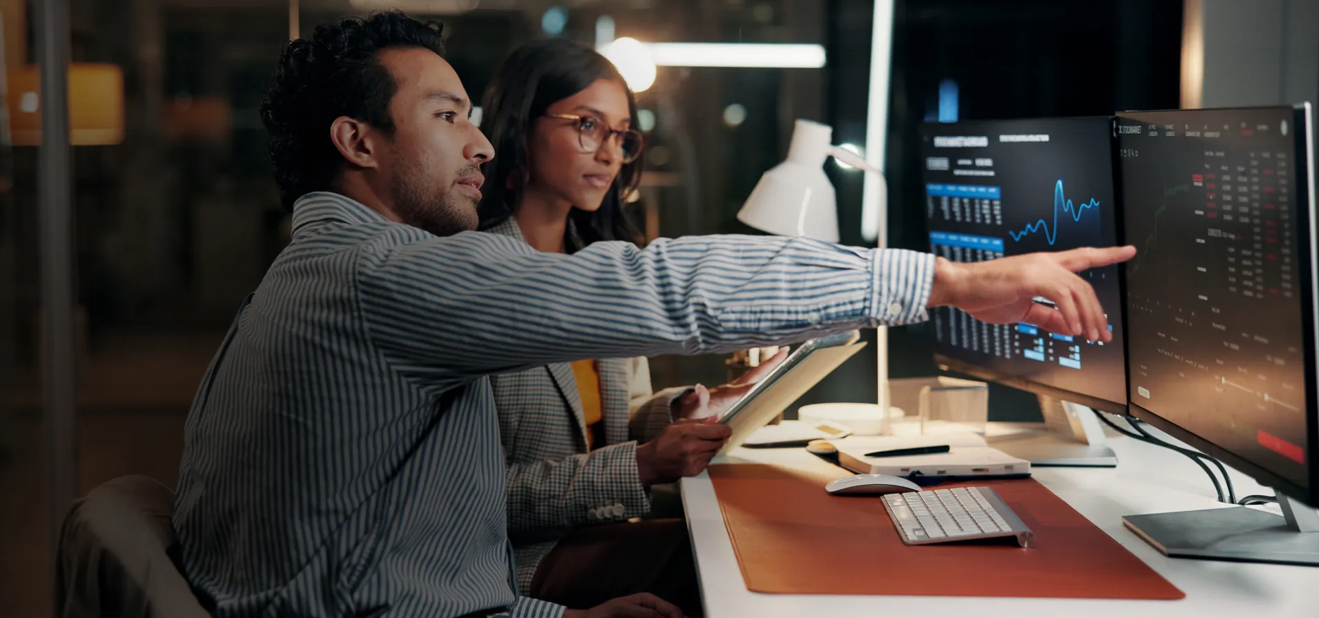 Streams of data cascading down a large display as an analyst looks on