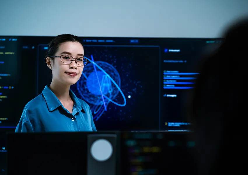 Insurance technology professional working at a computer with AI data visualizations