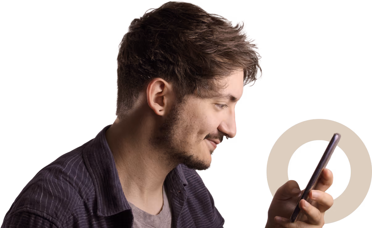 Young man looking at a smartphone with a slight smile on his face.