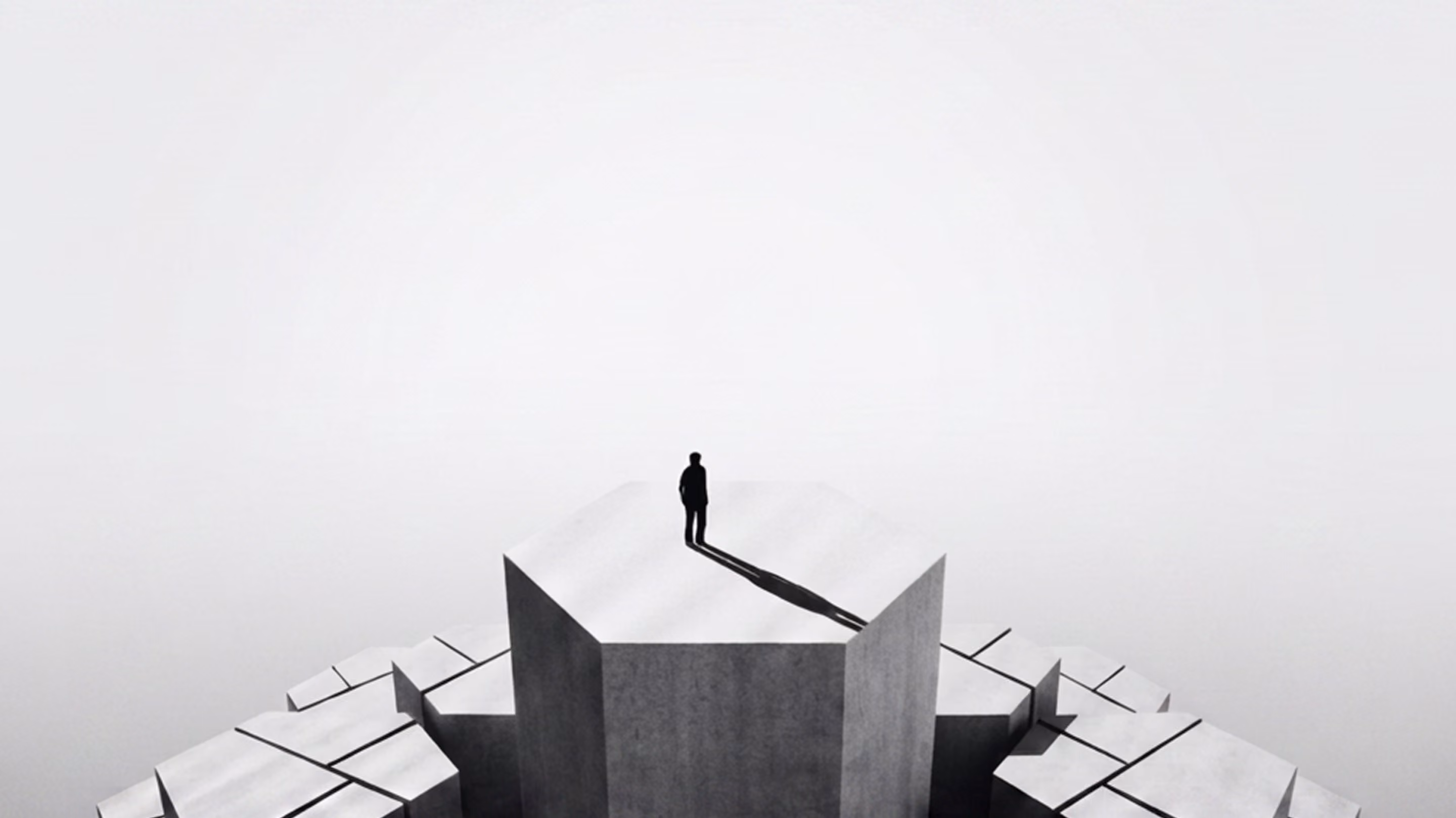 Silhouette of a person standing on a tall cracked concrete block casting a long shadow.