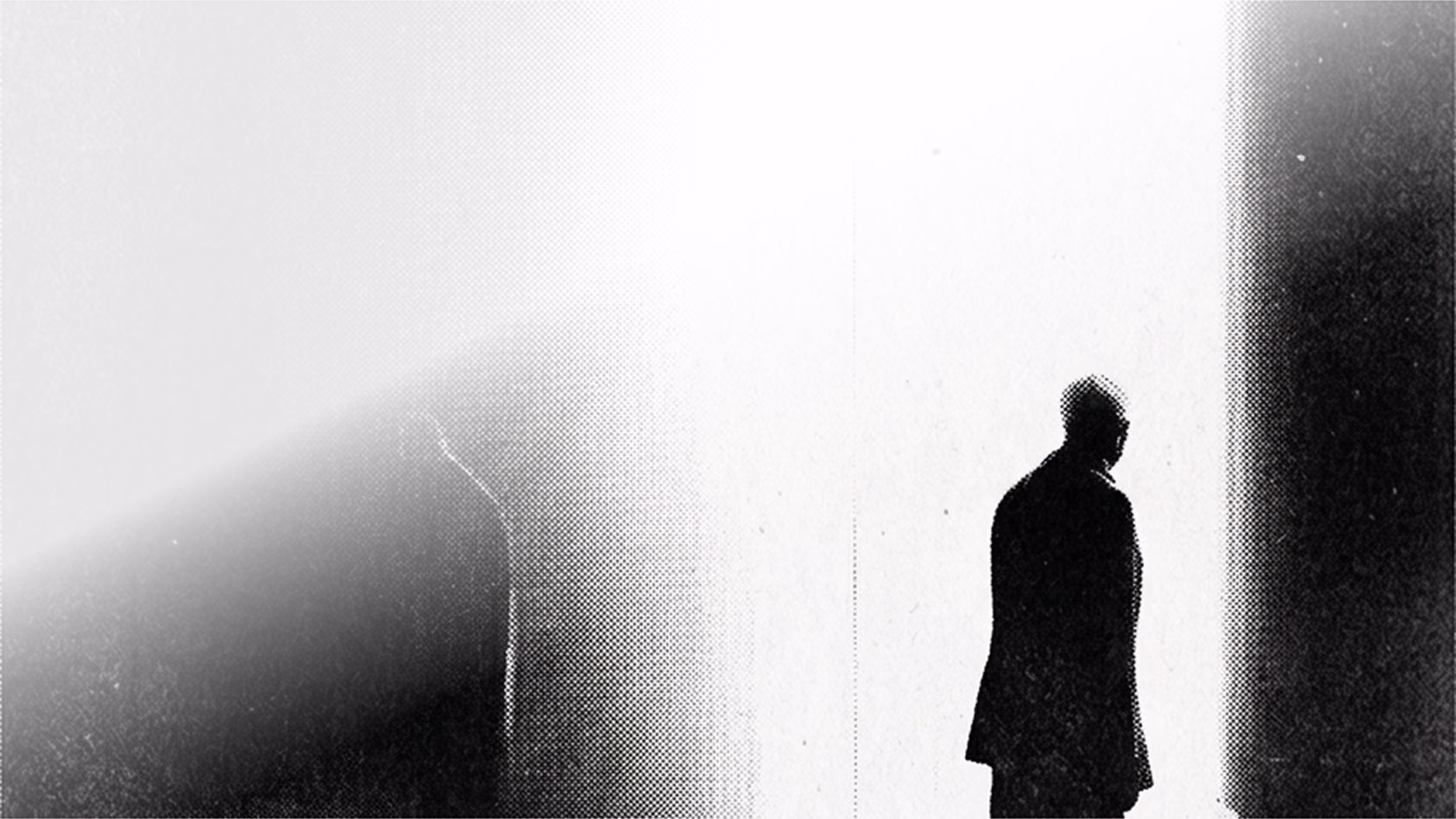 Black silhouette of a man in a doorway with light streaming in behind him.