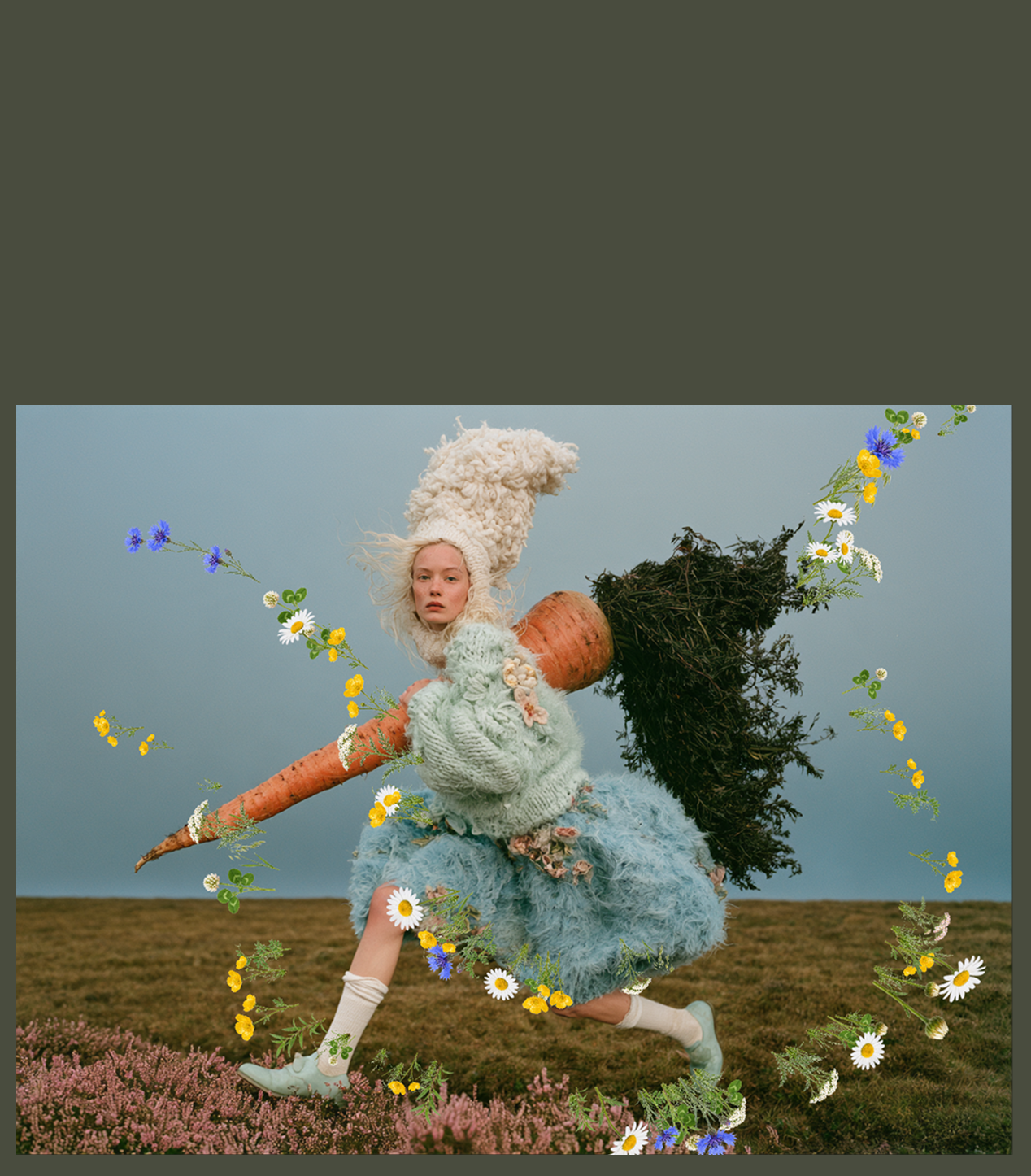 A model in fluffy knitwear running across heather with a giant carrot, surrounded by daisies, buttercups and cornflowers
