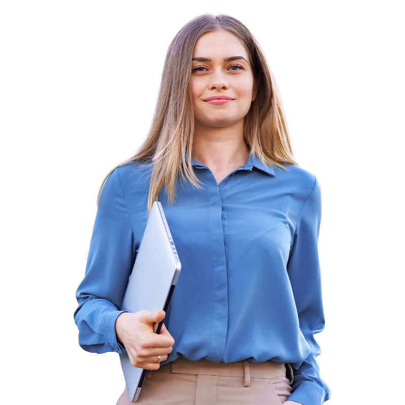 Jeune femme souriante avec une chemise bleue tenant un ordinateur portable sous son bras.