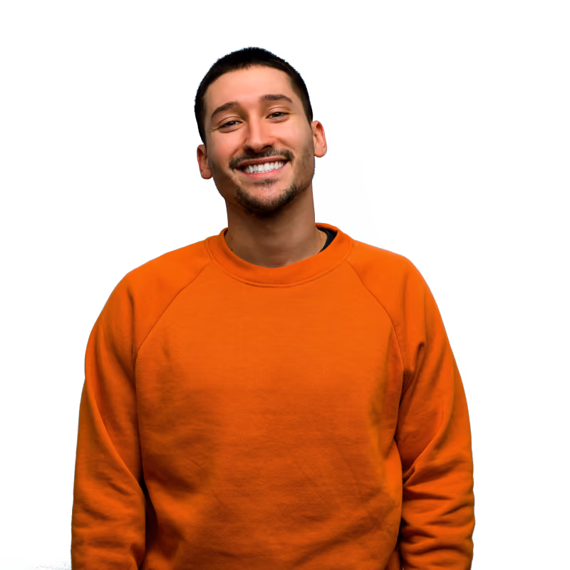 Jeune homme souriant portant un sweat-shirt orange, regardant vers l'avant sur fond transparent.