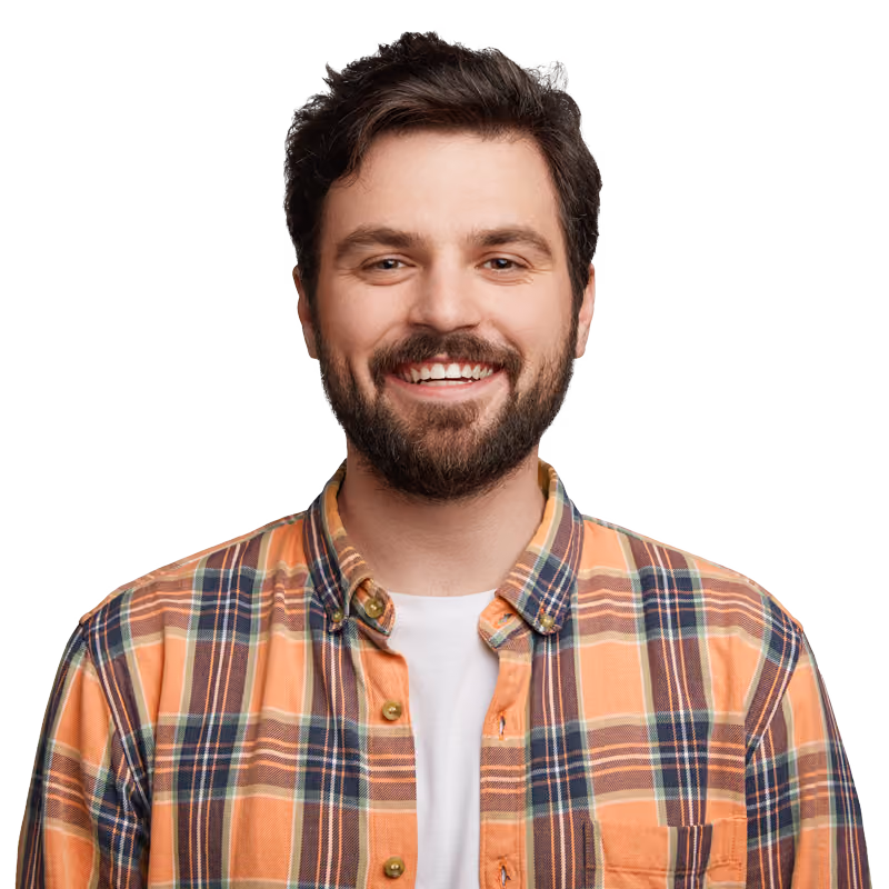 Homme avec barbe souriant portant une chemise à carreaux orange et blanche avec un t-shirt blanc en dessous.