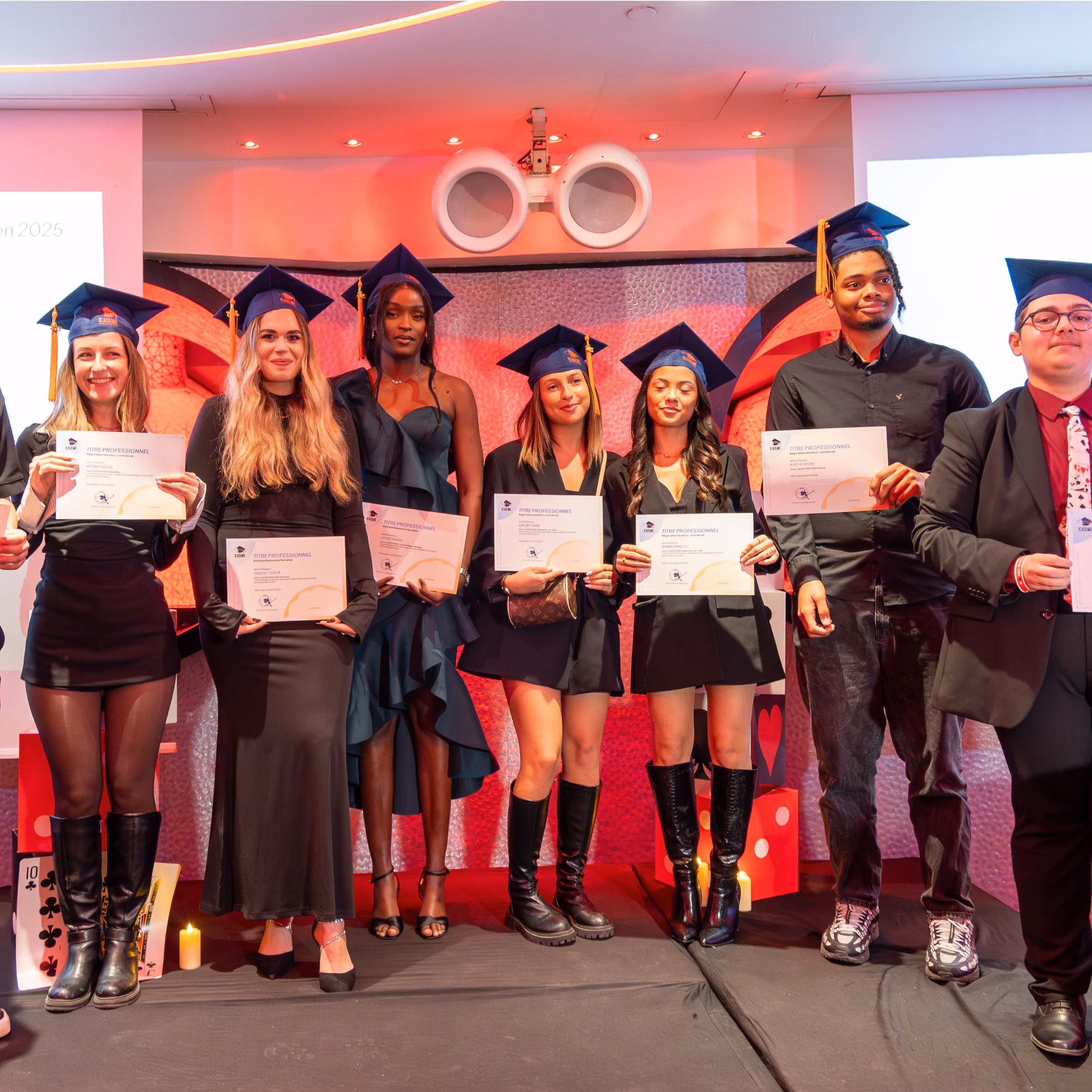 Diplômés en toque et robe posant avec leurs diplômes au campus de Paris