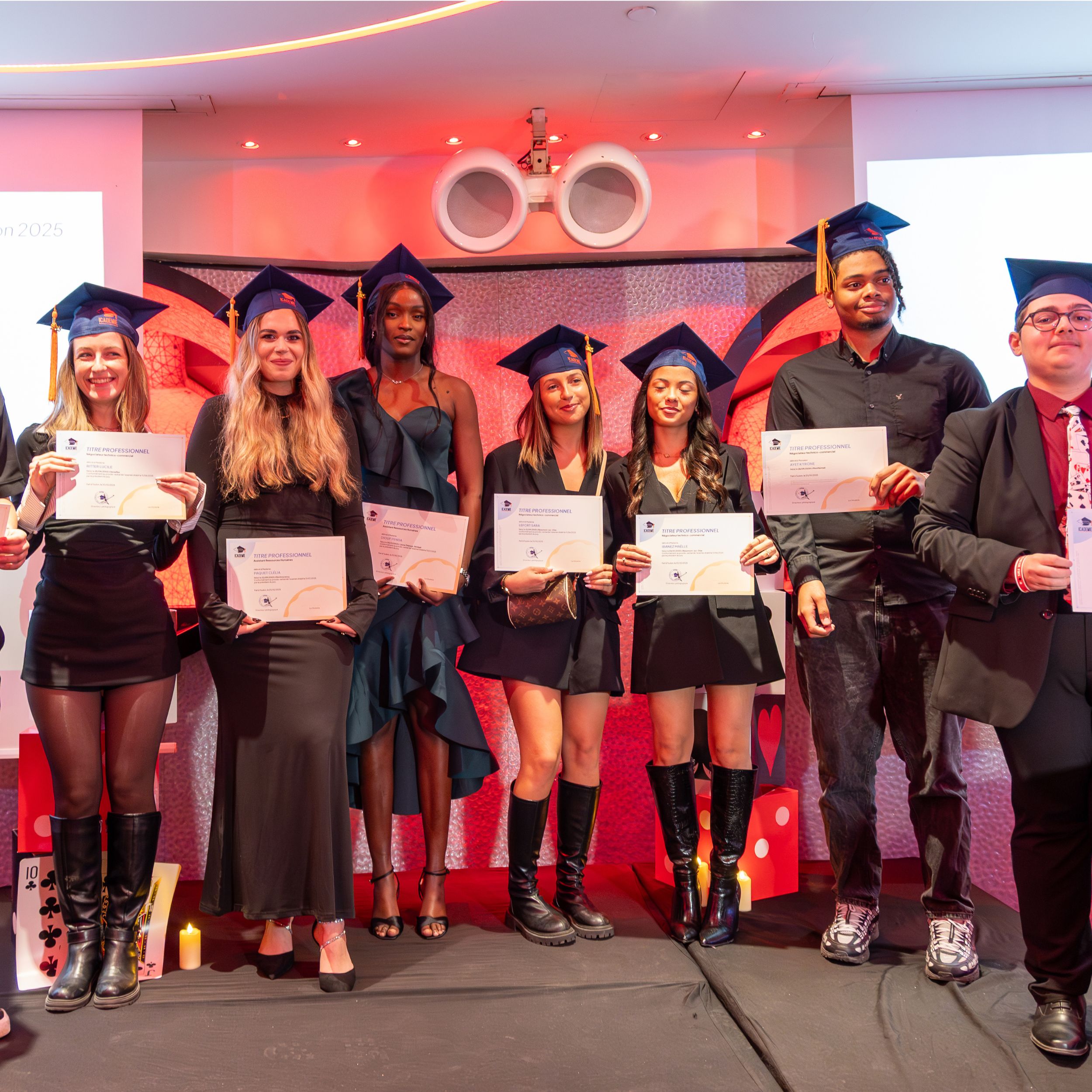 Diplômés en toque et robe posant avec leurs diplômes au campus de Paris