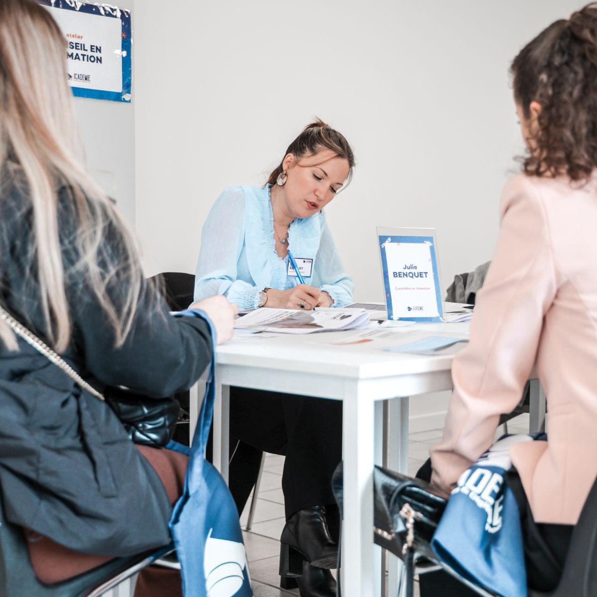 Conseillère en formation recevant deux candidates à son bureau au campus de Toulon