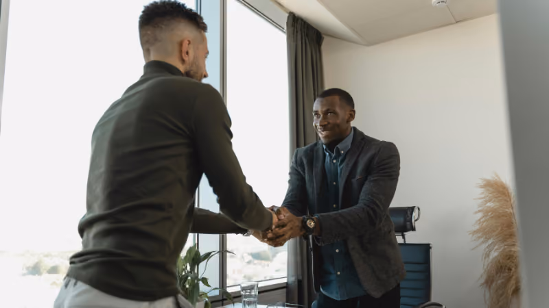 Deux hommes se serrant la main dans un bureau lors d'une rencontre