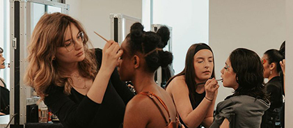 Élèves maquilleuses s'exerçant sur des modèles lors d'un atelier